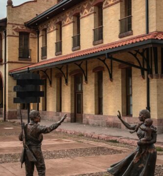 a statue of two people holding a sign in front of a building